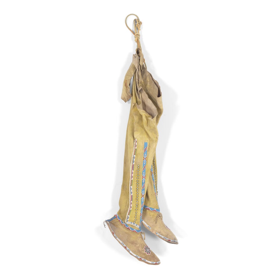 A pair of Heévâhetaneo'o (Southern Cheyenne) girl's beaded high-top moccasins: A pair of Heévâhetaneo'o (Southern Cheyenne) girl's beaded high-top moccasins Of hide construction with ochre pigment throughout, the leggings worked with two rows of geometric beadwork