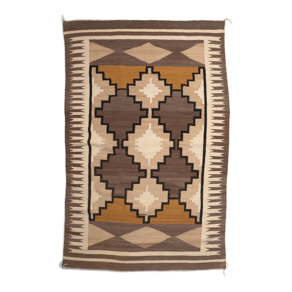 A Diné (Navajo) rug: A Diné (Navajo) rug Worked with chains of stepped diamonds framed within wide borders. size approximately 4ft 5 1/2in x 6ft 9 1/2in Footnotes: Provenance The Collection of Gordon and Zanne Stewar