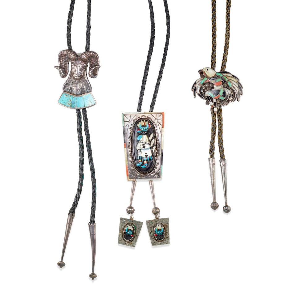 Three Zuni or Southwest silver and inlay bolo ties: Three Zuni or Southwest silver and inlay bolo ties Each of silver and set with various stones, comprising: a Shalako-motif example, the inlay framed within a stamped silver and multi-stone inlay