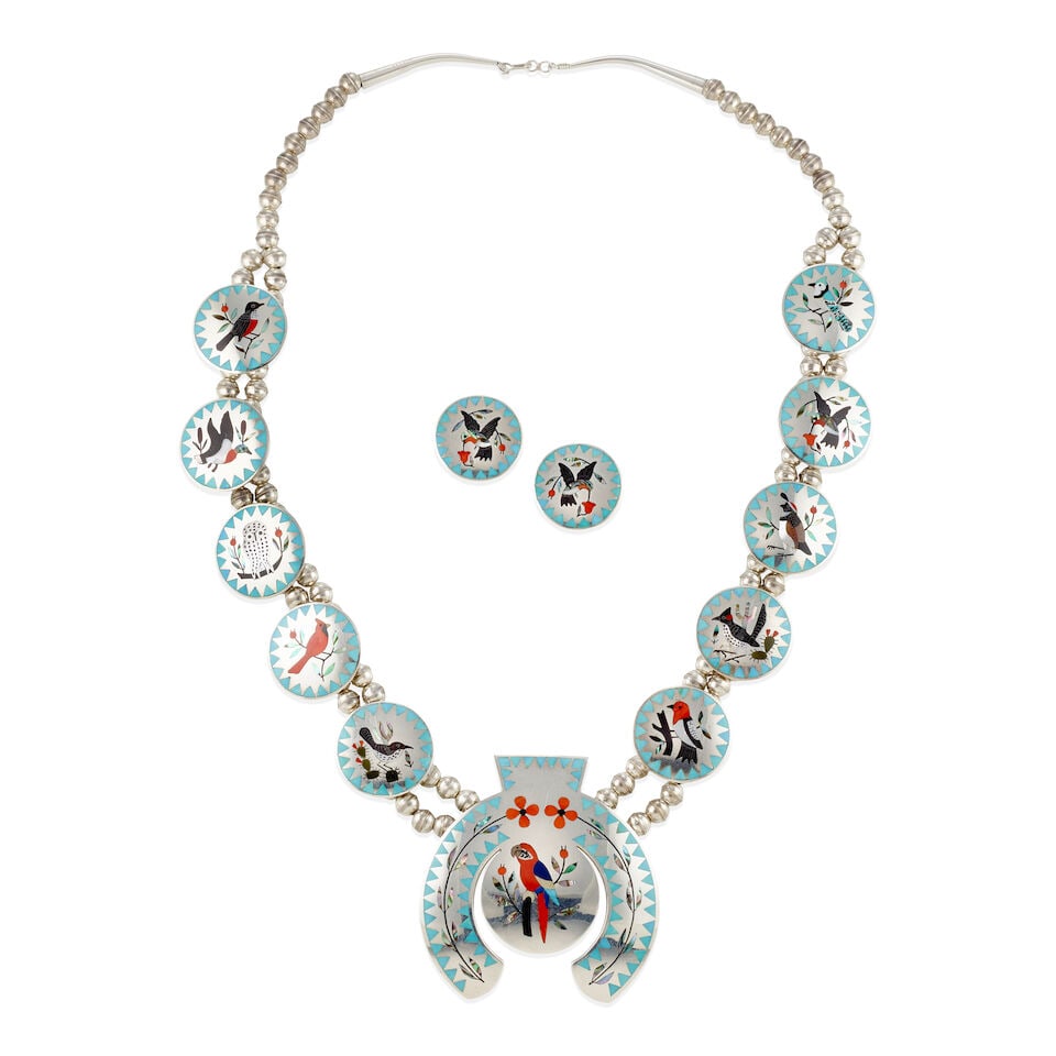 A Dennis and Nancy Edaakie necklace and matching earrings: Dennis and Nancy Edaakie Zuni, (b. 1931 and b. 1937), an avian motif silver necklace and matching earrings, the necklace with large naja set with mosaic parrot, flanked by ten circular plaques, each