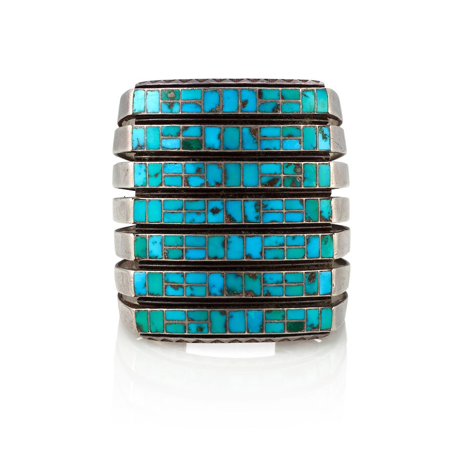 A Zuni multi-row channel inlay cuff bracelet: A Zuni multi-row channel inlay cuff bracelet A seven-row silver channel inlay cuff bracelet set with rectangular turquoise. inner circumference (including gap) 6 3/8in, gap 7/8in, width 2 5/8in;