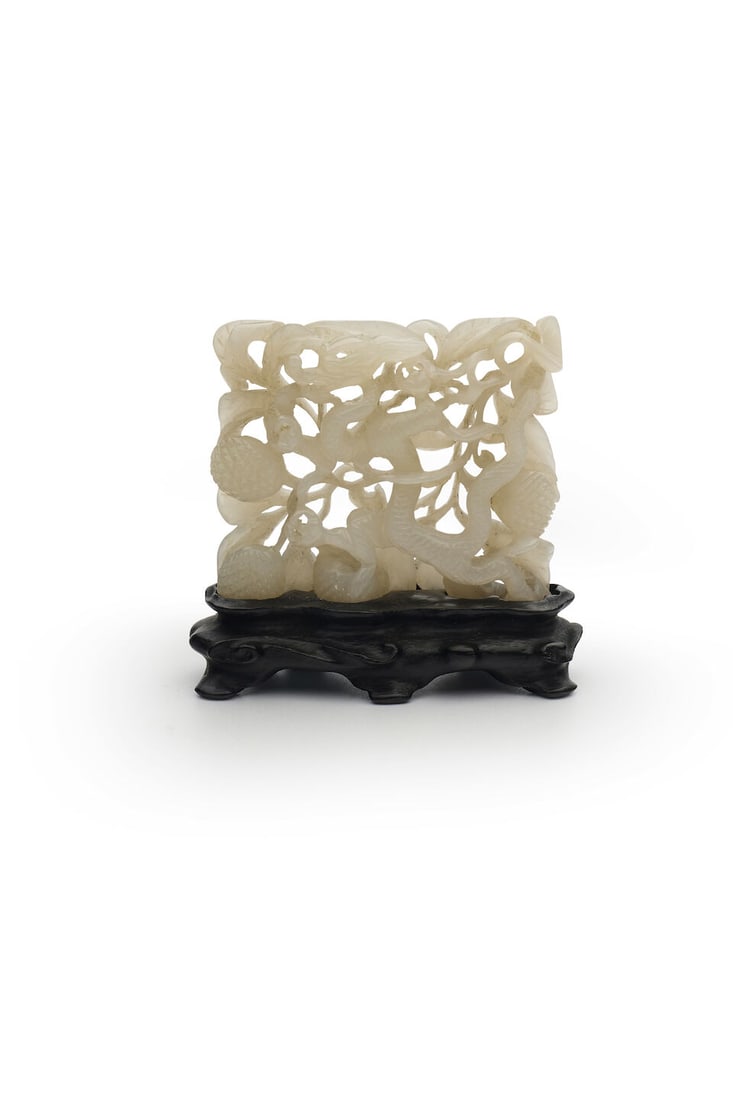 A RETICULATED WHITE JADE 'DRAGON' PLAQUE Ming dynasty: A RETICULATED WHITE JADE 'DRAGON' PLAQUE Ming dynasty with a stand, 5.6cm high, 54g Footnotes: 明 鏤雕龍紋牌 及座 For further information on this lot