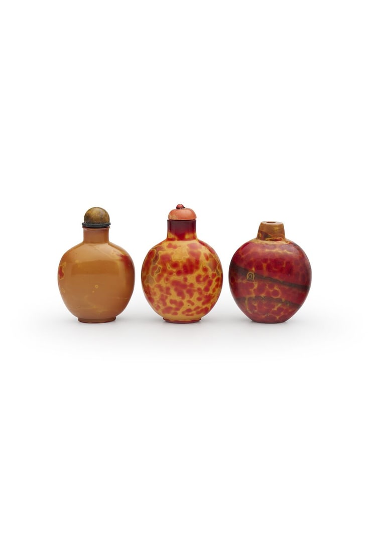 THREE REALGAR GLASS SNUFF BOTTLES Late Qing dynasty (3): THREE REALGAR GLASS SNUFF BOTTLES Late Qing dynasty Measured without the stoppers varying sizes from 5.7cm to 6.3cm high (3). Footnotes: 晚清