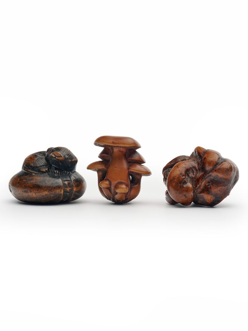 THREE WOODEN NETSUKE The 'shimeji mushrooms' signed Masanao [正直], 19th century (3): THREE WOODEN NETSUKE The 'shimeji mushrooms' signed Masanao [正直], 19th century comprising one 'shimeji mushrooms', one of an anaguma seated on a futon, and one 'tree trunk', varying size