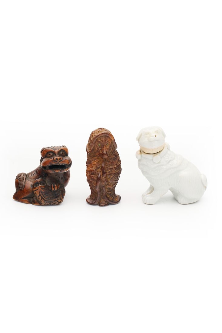TWO WOOD NETSUKE AND A WHITE GLAZED NETSUKE OF A DOG 19th/20th century (3): TWO WOOD NETSUKE AND A WHITE GLAZED NETSUKE OF A DOG 19th/20th century Varying sizes from 3.7cm to 5.0cm high (3). For further information on this lot please visit Bonhams.com For further