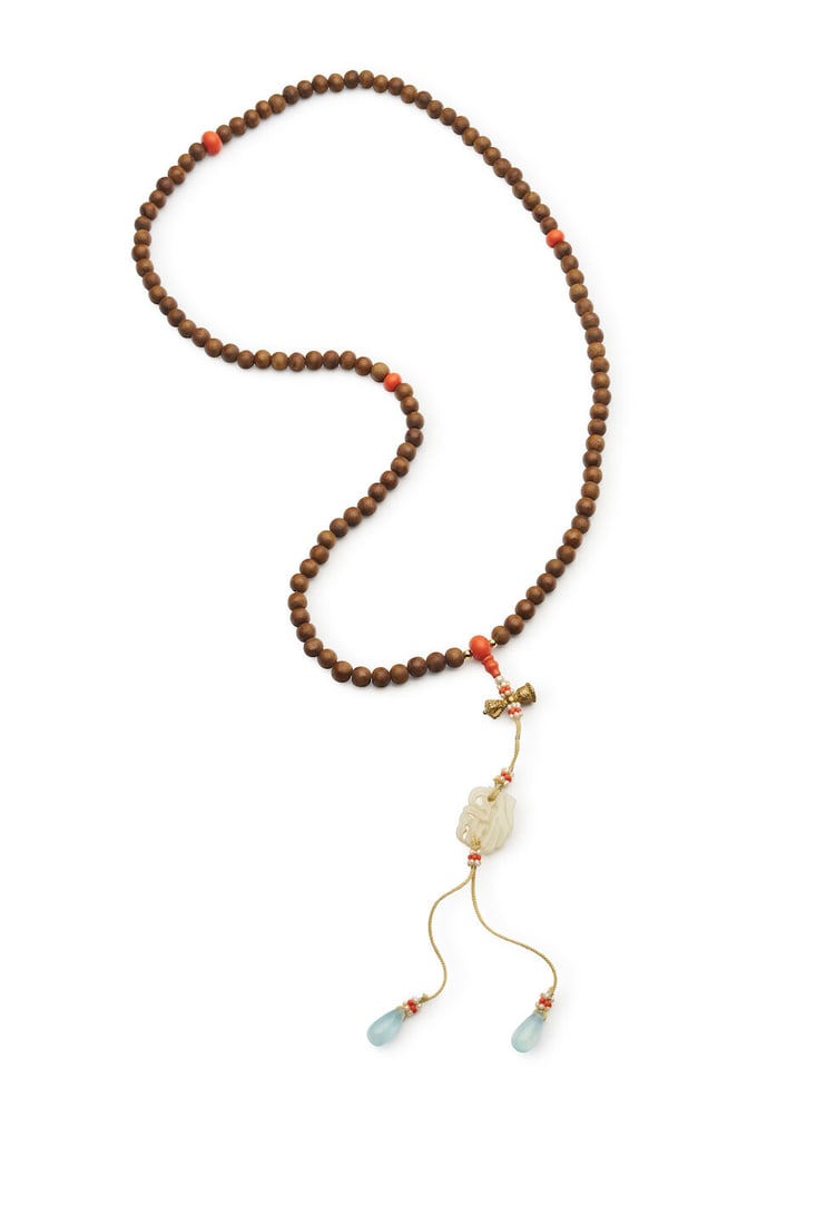 AN ALOESWOOD BEADED NECKLACE 20th century: AN ALOESWOOD BEADED NECKLACE 20th century comprising 108 beads with coral glass separators, and a white jade pendant, with a fitted box, each bead approx. 0.7cm diam., the necklace fully suspended 55.