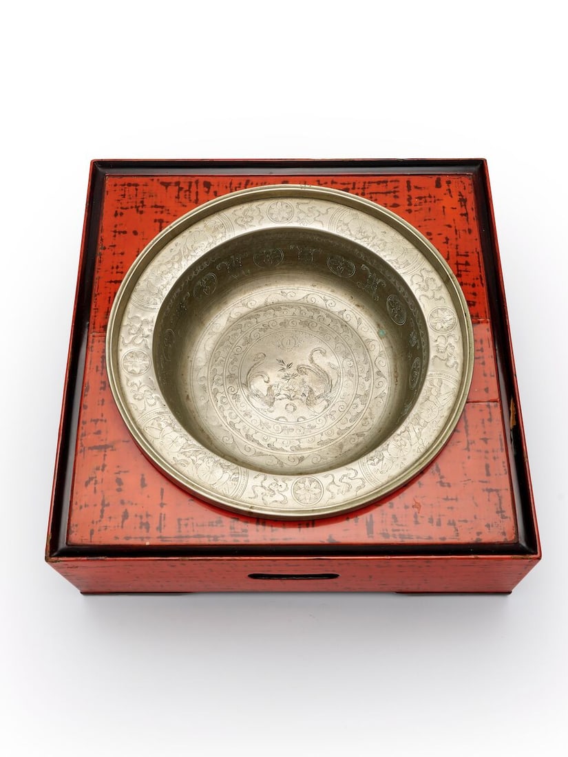 A COPPER ALLOY 'PHOENIX AND SUN' BASIN AND A LACQUER BASE 19th century: A COPPER ALLOY 'PHOENIX AND SUN' BASIN AND A LACQUER BASE 19th century Basin 32.3cm diam., base:39.0 x 39.0 x 14.5cm Footnotes: Provenance: Moss Green, Melbourne, 16 Nov 2015, lot