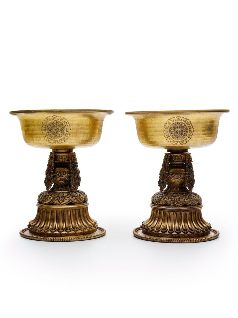 A PAIR OF GILT COPPER ALLOY 'BUDDHIST EMBLEMS' OIL LAMPS Tibet, 20th century (2): A PAIR OF GILT COPPER ALLOY 'BUDDHIST EMBLEMS' OIL LAMPS Tibet, 20th century 18.9cm (2). Footnotes: 西藏 二十世紀