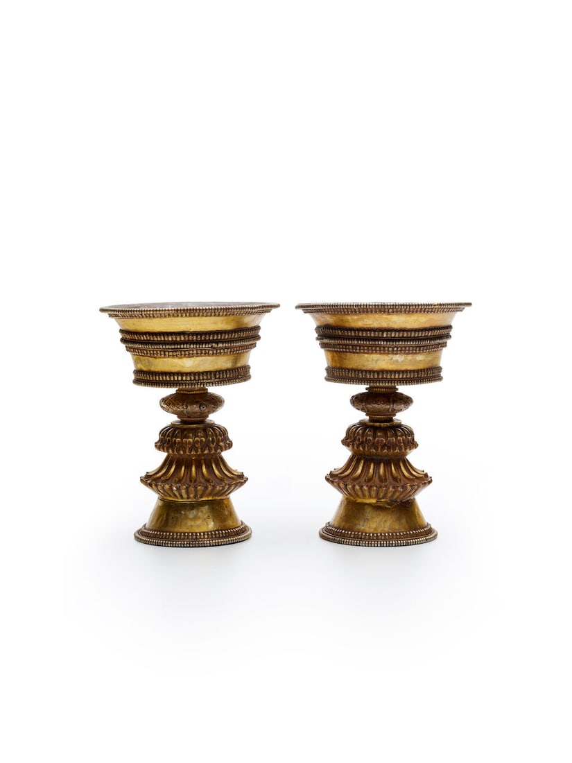 A PAIR OF GILT COPPER ALLOY OIL LAMPS Tibet, 20th century (2): A PAIR OF GILT COPPER ALLOY OIL LAMPS Tibet, 20th century 13.2cm high. each (2). Footnotes: 西藏 二十世紀