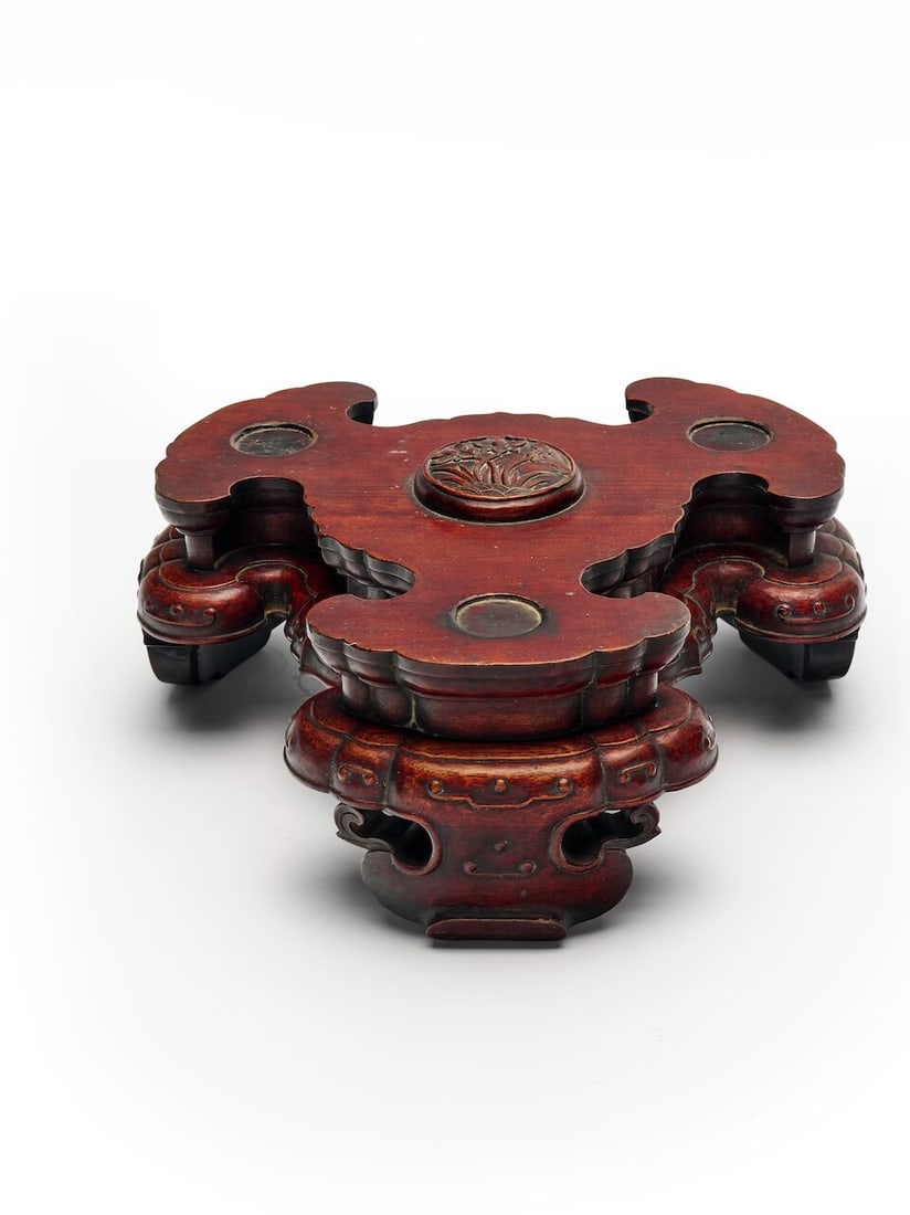 A ROSEWOOD 'LOTUS' STAND FOR A TRIPOD INCENSE BURNER Late Qing dynasty: A ROSEWOOD 'LOTUS' STAND FOR A TRIPOD INCENSE BURNER Late Qing dynasty 30.0cm wide, 14.0cm high Footnotes: 晚清 紅木蓮塘紋三足香爐