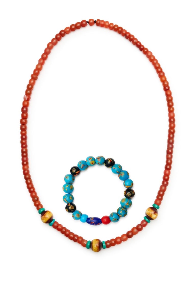 A 'PHOENIX EYE' GLASS BEADED BRACELET, AND A CARNELIAN AND AMBER BEADED NECKLACE 19th/20th centu...: A 'PHOENIX EYE' GLASS BEADED BRACELET, AND A CARNELIAN AND AMBER BEADED NECKLACE 19th/20th century the 'eye' beads approx. 1.2cm diam. each, the carnelian necklace fully suspended 32.5cm long (2). For