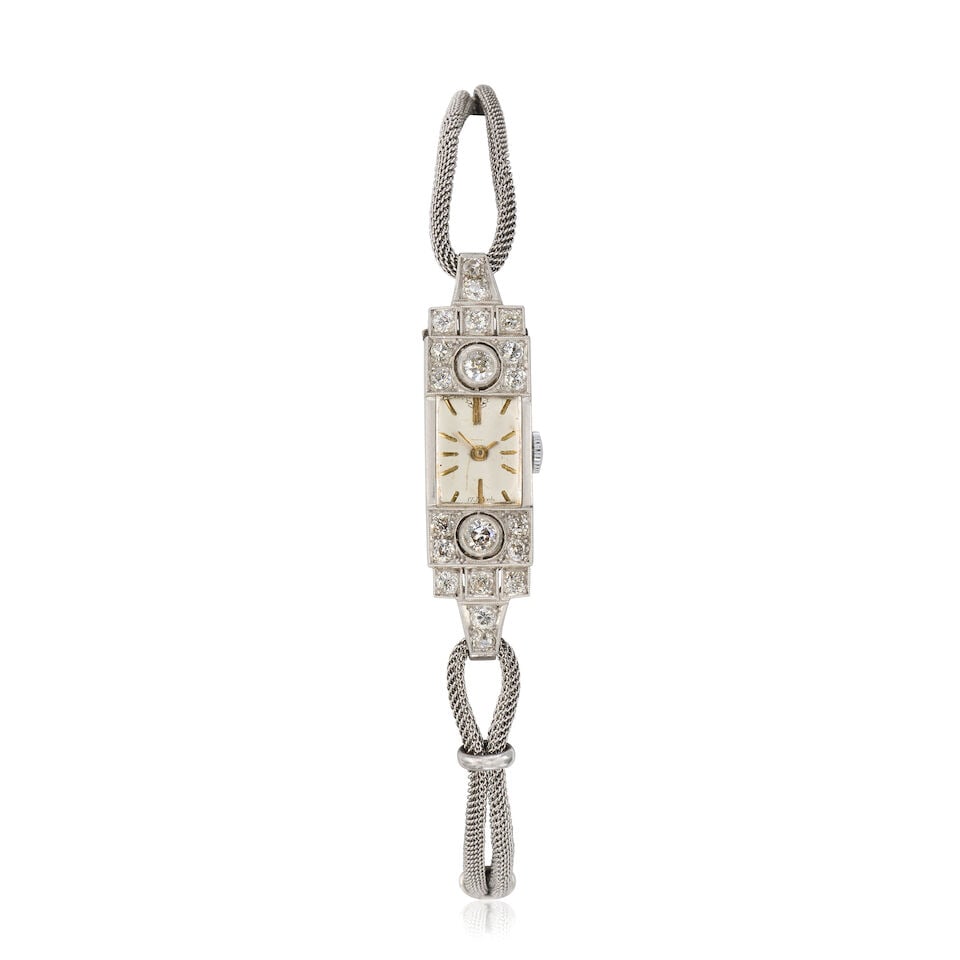 A lady's platinum and diamond set manual wind bracelet watch Circa 1920: A lady's platinum and diamond set manual wind bracelet watch Date: Circa 1920 Movement: 17-jewel manual wind Dial: Silvered Case: Engraved rectangular form, diamond set bezel Strap/Bracelet: ##9K