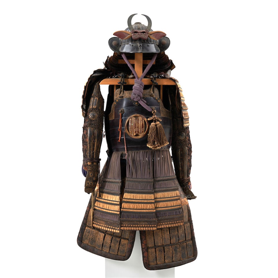 A Black-lacquer Suit of Armor and Kabuto. (Helmet) Japan, 18th/19th century, (2): A Black-lacquer Suit of Armor and Kabuto. (Helmet) Japan, 18th/19th century, Hawk-feather mon at the chest and on the helmet fukigaeshi. 35in (88.9cm) long; helmet bowl 9 1/2in (24.1cm) diam 2 For fur
