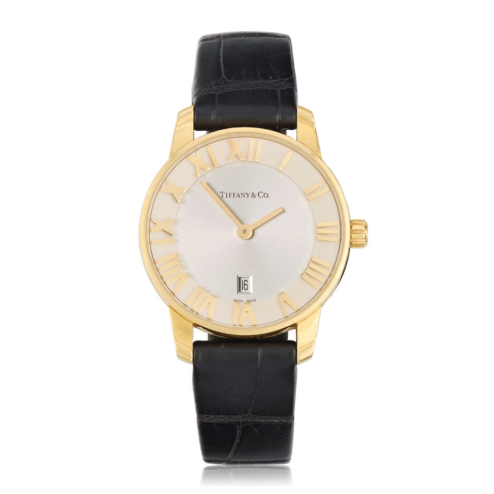 Tiffany & Co. A lady's 18K gold quartz calendar wristwatch Atlas, Circa 2010: Tiffany & Co. A lady's 18K gold quartz calendar wristwatch Model: Atlas Date: Circa 2010 Movement: 6-jewel ETA Cal. 256.041 quartz Dial: Silvered, applied Roman numeral hour markers, date aperture at