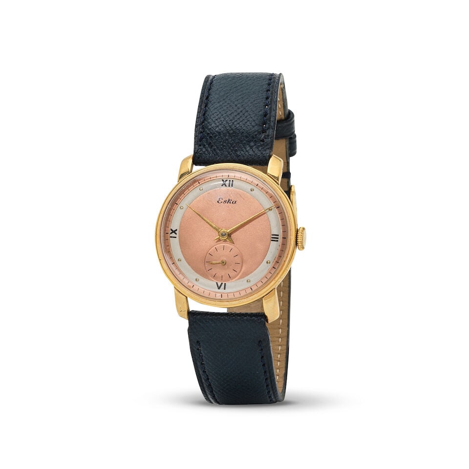 Eska. A gold plated manual wind wristwatch Eska. Montre bracelet en plaqué or mouvement m&#...: Eska. A gold plated manual wind wristwatch Eska. Montre bracelet en plaqué or mouvement mécanique Date: Circa 1950 Movement: 17-jewel ETA Cal.900 manual wind Dial: Pink salmon, signed Case: