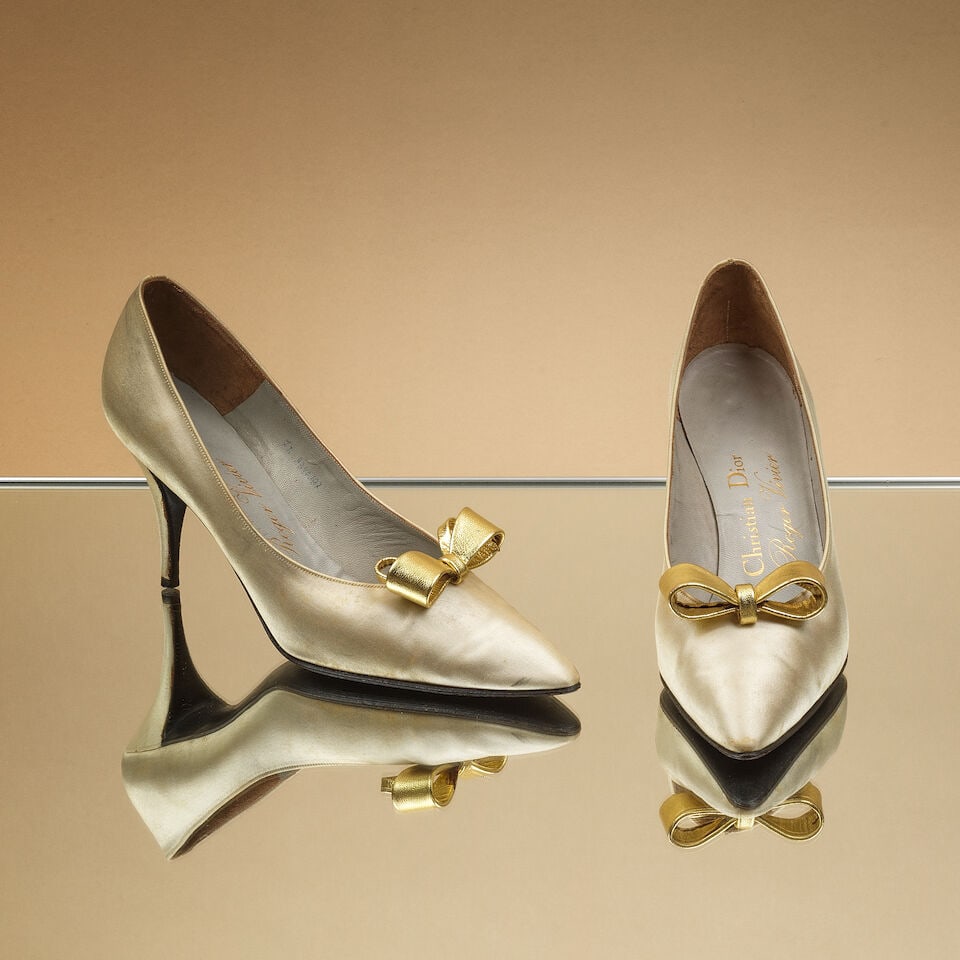 Christian Dior créé par Roger Vivier, circa 1960. Paire d'escarpins en soie ivoire et ...: Christian Dior créé par Roger Vivier, circa 1960. Paire d'escarpins en soie ivoire et noeud en cuir or. Christian Dior created by Roger Vivier. Pair of ivory silk pumps with a gold leather b
