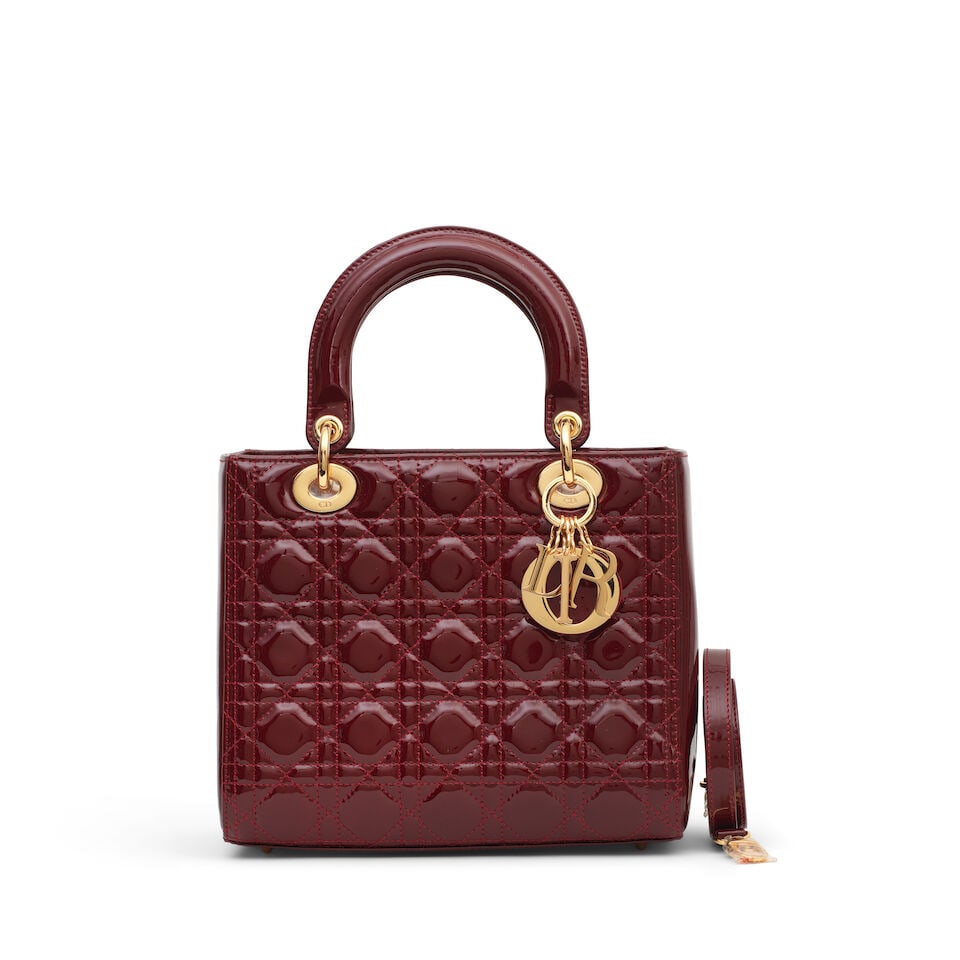Christian Dior: a Deep Red Patent Leather Medium Lady Dior 2010 (includes shoulder strap and dus...: Christian Dior: a Deep Red Patent Leather Medium Lady Dior 2010 Creative Director: John Galliano Patent red leather with gold tone hardware Condition Grade B+ 23cm wide, 20cm high, 12cm deep, 10cm han