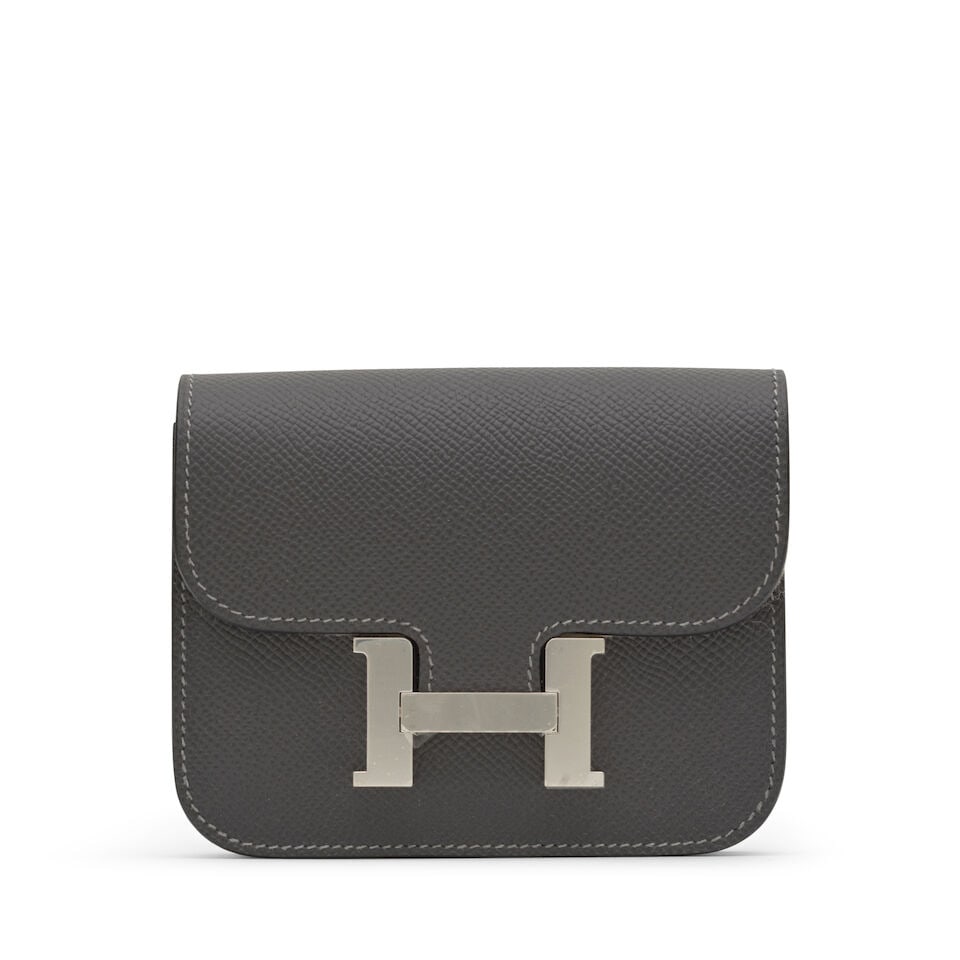 Hermès: a Graphite Epsom Leather Constance Slim Wallet 2024 (includes felt protector, dust ...: Hermès: a Graphite Epsom Leather Constance Slim Wallet 2024 Wallet with belt buckle loop, together with a removable zipped pochette, palladium hardware Condition Grade A 12.5cm wide, 10cm high, 2