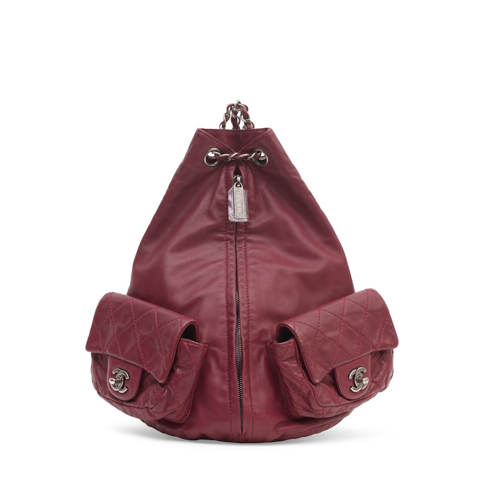 Chanel: a Burgundy Lambskin Backpack 2012-13 (includes serial sticker and dust bag): Chanel: a Burgundy Lambskin Backpack 2012-13 Creative Director: Karl Lagerfeld Burgundy lambskin with quilted pockets at the front, central zip with drawstring top opening, gunmetal tone hardware Cond