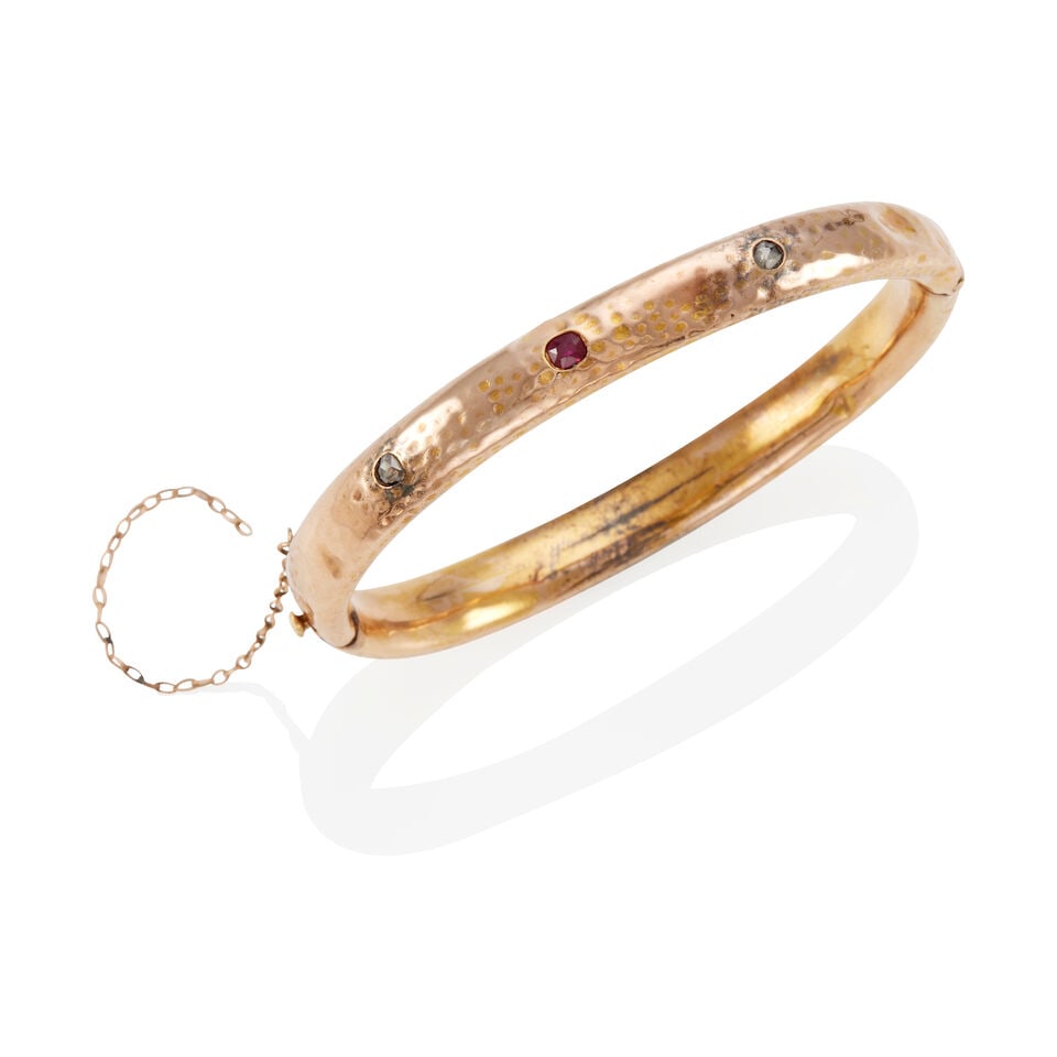 ANTIQUE 14K GOLD BANGLE WITH GEMSTONES: ANTIQUE 14K GOLD BANGLE WITH GEMSTONES • 14k yellow to rose gold • 1 red center stone, 2 rose-cut colorless stones (1 tested for diamond) • Inner circumference 6 1/4 in. •