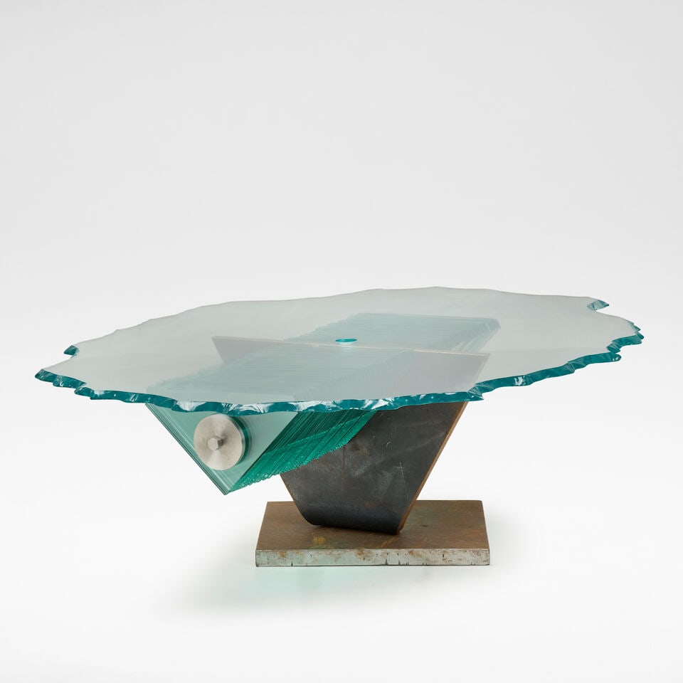 Danny Lane Coffee table: Danny Lane Coffee table Cut glass, steel, patinated steel, with triangular glass plates supporting the irregular shaped table top, supported on a curved triangular and square base. 59 cm high, 160 cm
