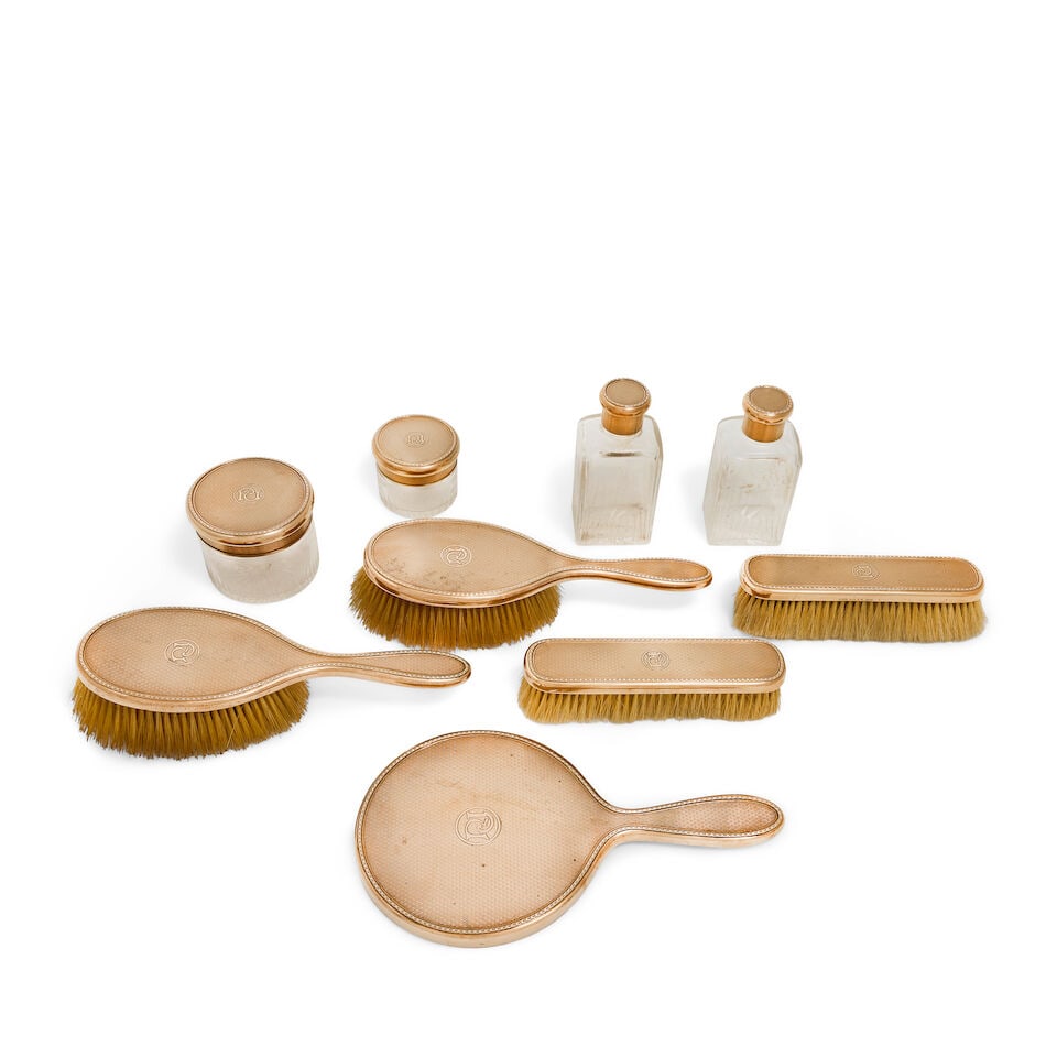 A 9 carat gold nine-piece dressing set with a crocodile covered travelling case Asprey & Co Ltd,... - 2