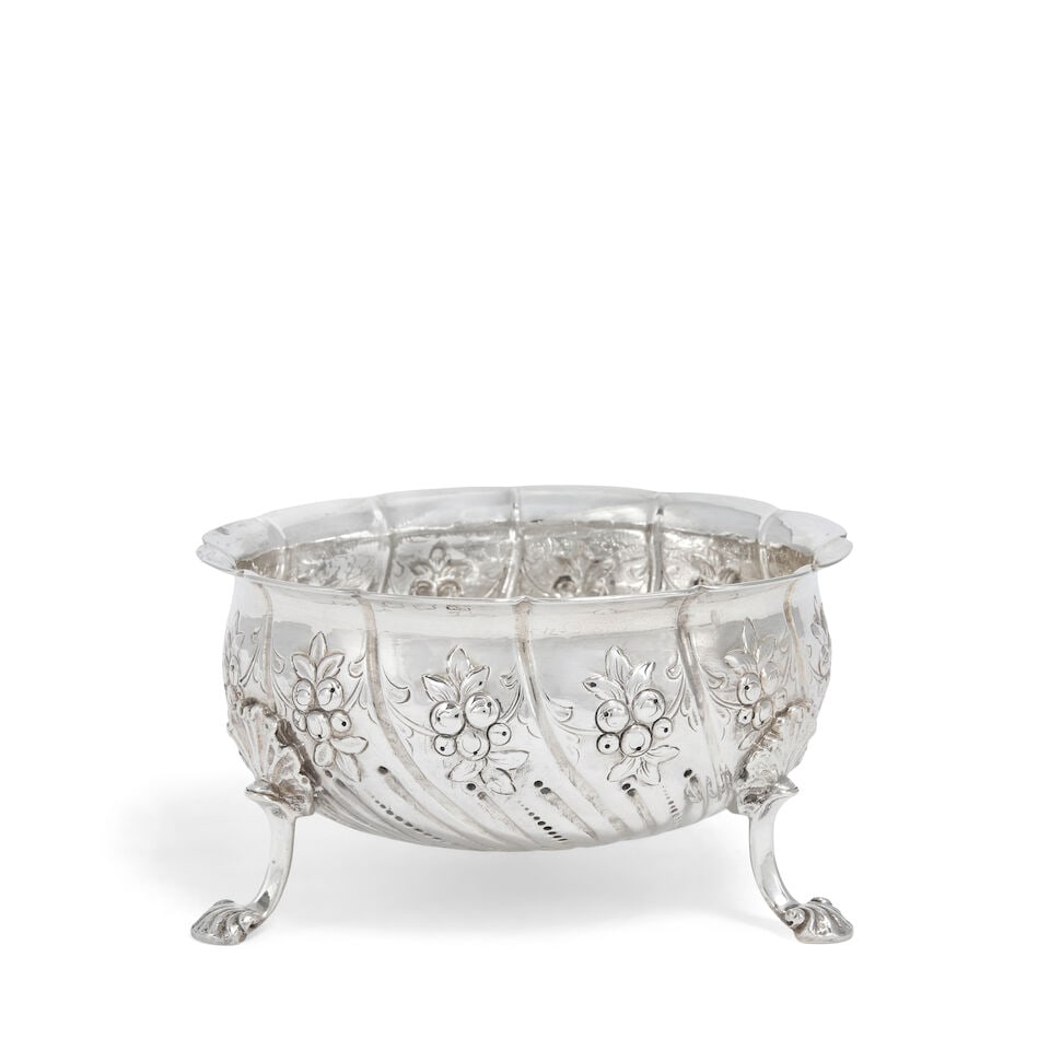 A George III Irish silver sugar bowl Richard Sawyer, Dublin, circa 1800: A George III Irish silver sugar bowl Richard Sawyer, Dublin, circa 1800 Conventional form with shaped fluted rim and fluted sides, each chased with flowers, raised on three shell feet, capped with sca