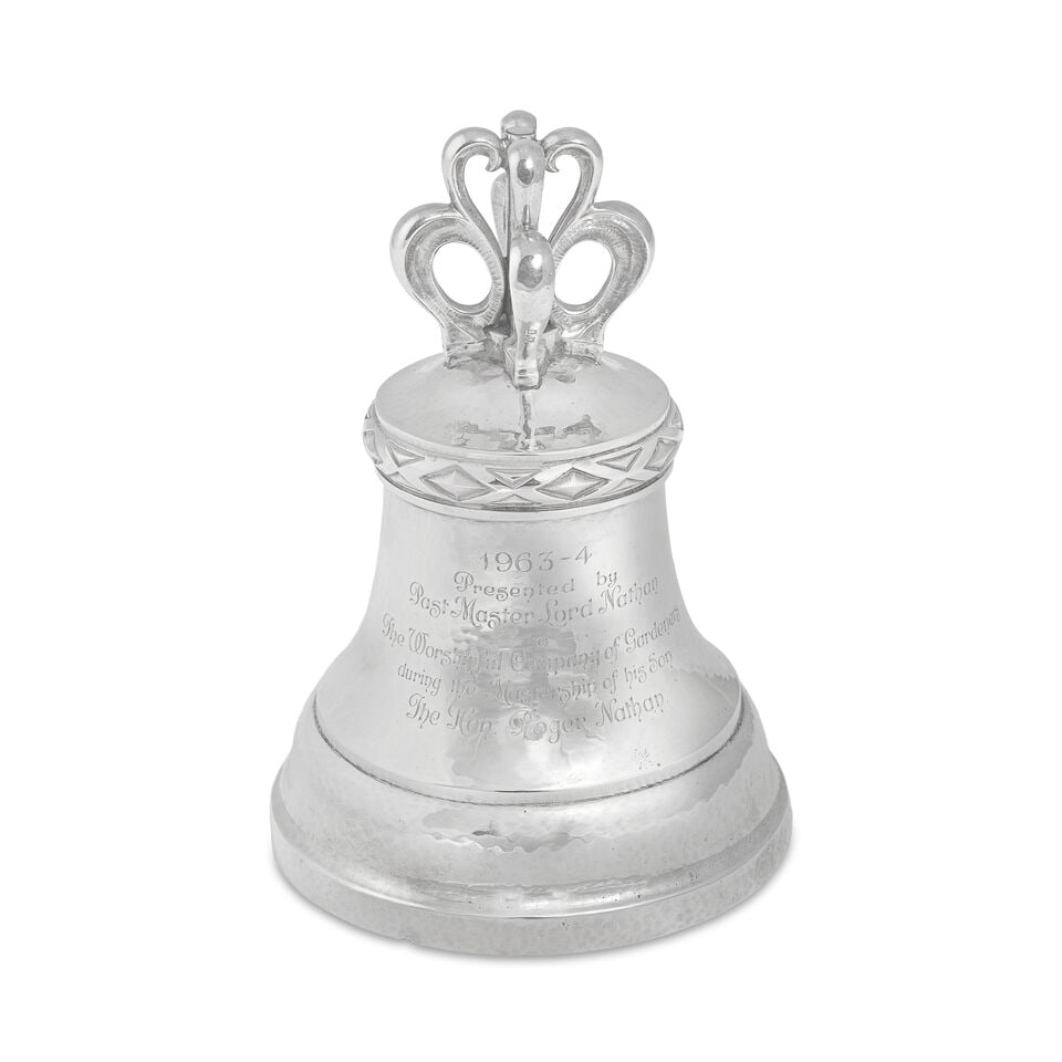 OMAR RAMSDEN: a silver table bell London 1932: OMAR RAMSDEN: a silver table bell London 1932 The slightly domed top surmounted with four scroll suspension loops (canons), diamond band below, the flared body with engraved presentation inscription '