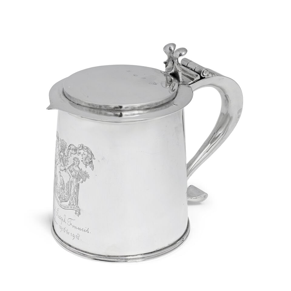 A Charles II silver lidded tankard maker's mark WM with crown above and device below, London 1664: A Charles II silver lidded tankard maker's mark WM with crown above and device below, London 1664 The hinged stepped flat top cover with point at the front, scroll thumb piece, the slightly tapering b