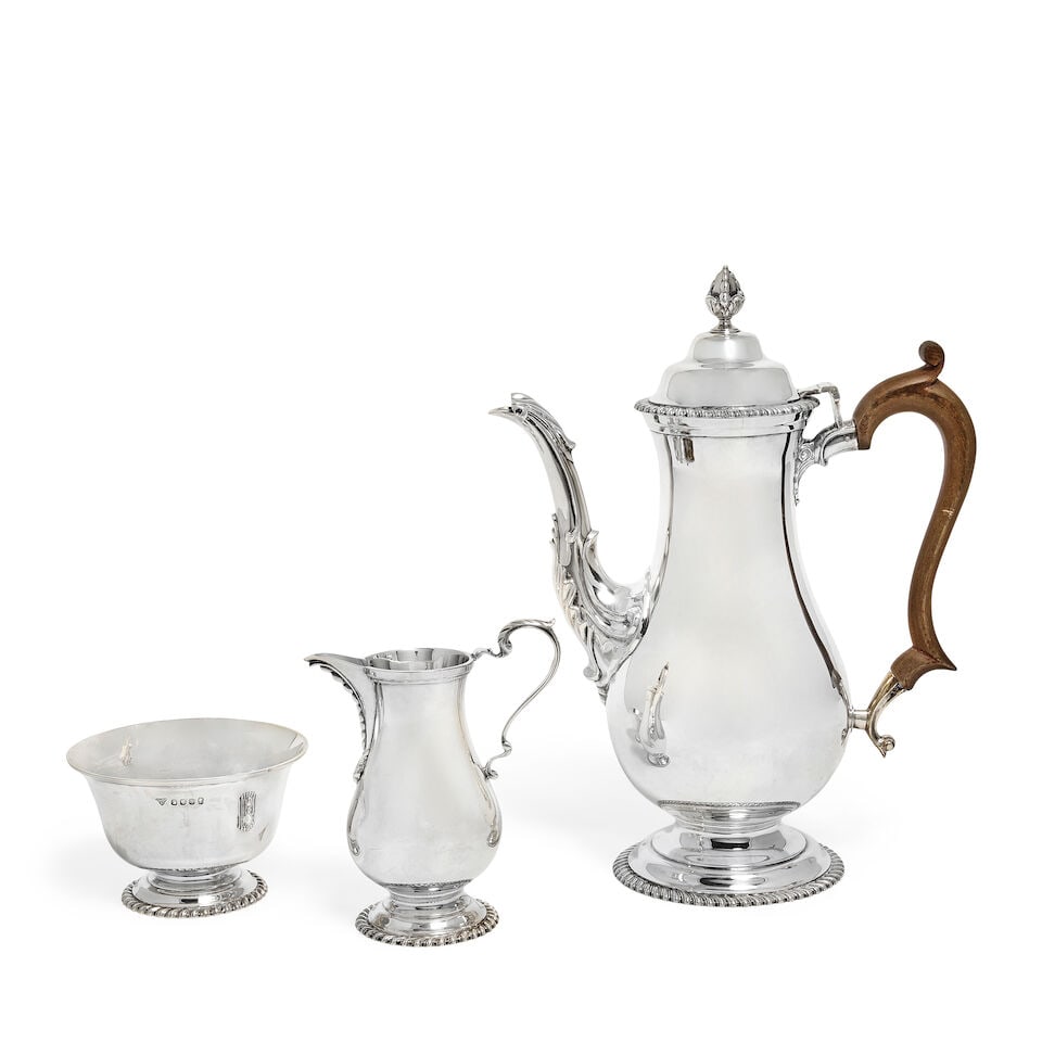 A silver three-piece coffee service Garrard & Co Ltd, London 1977 (3): A silver three-piece coffee service Garrard & Co Ltd, London 1977 In the 18th century manner, comprising, coffee pot of plain baluster form, hinged dome cover, leaf embellished spout and wood scroll h