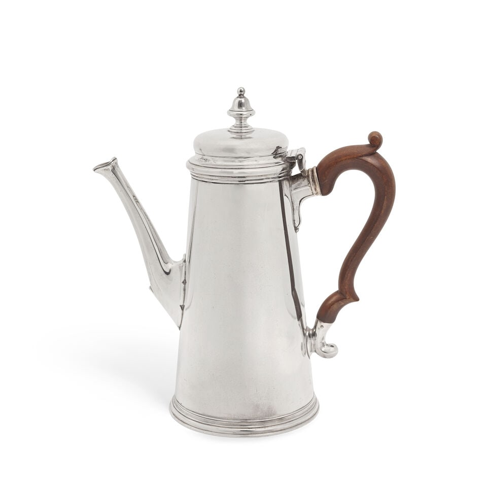 A silver coffee pot D & J Wellby Ltd, London 1959: A silver coffee pot D & J Wellby Ltd, London 1959 Tapering straight plain sides, with domed cover with urn finial, with stepped foot, with wood scroll handle, height 23cm, weight total 23oz. For furth