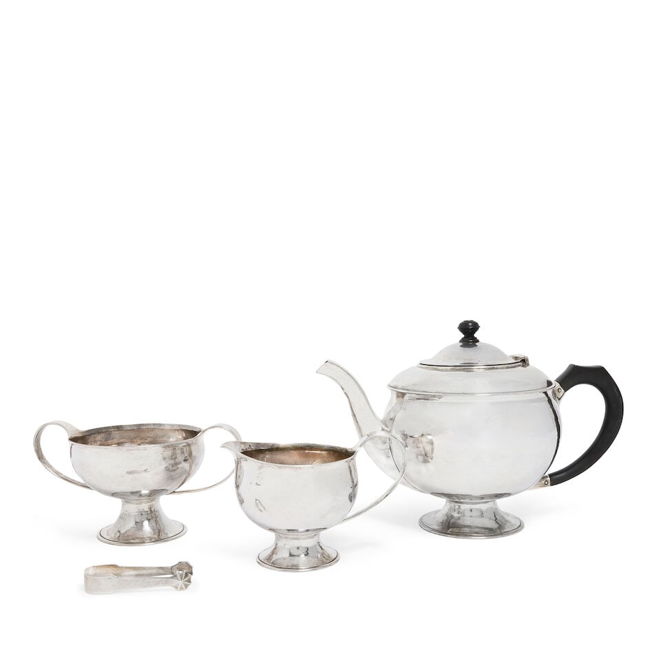 A rare Arts and Crafts silver three-piece tea service with a pair of sugar tongs teapot with mar... (1 of 2)