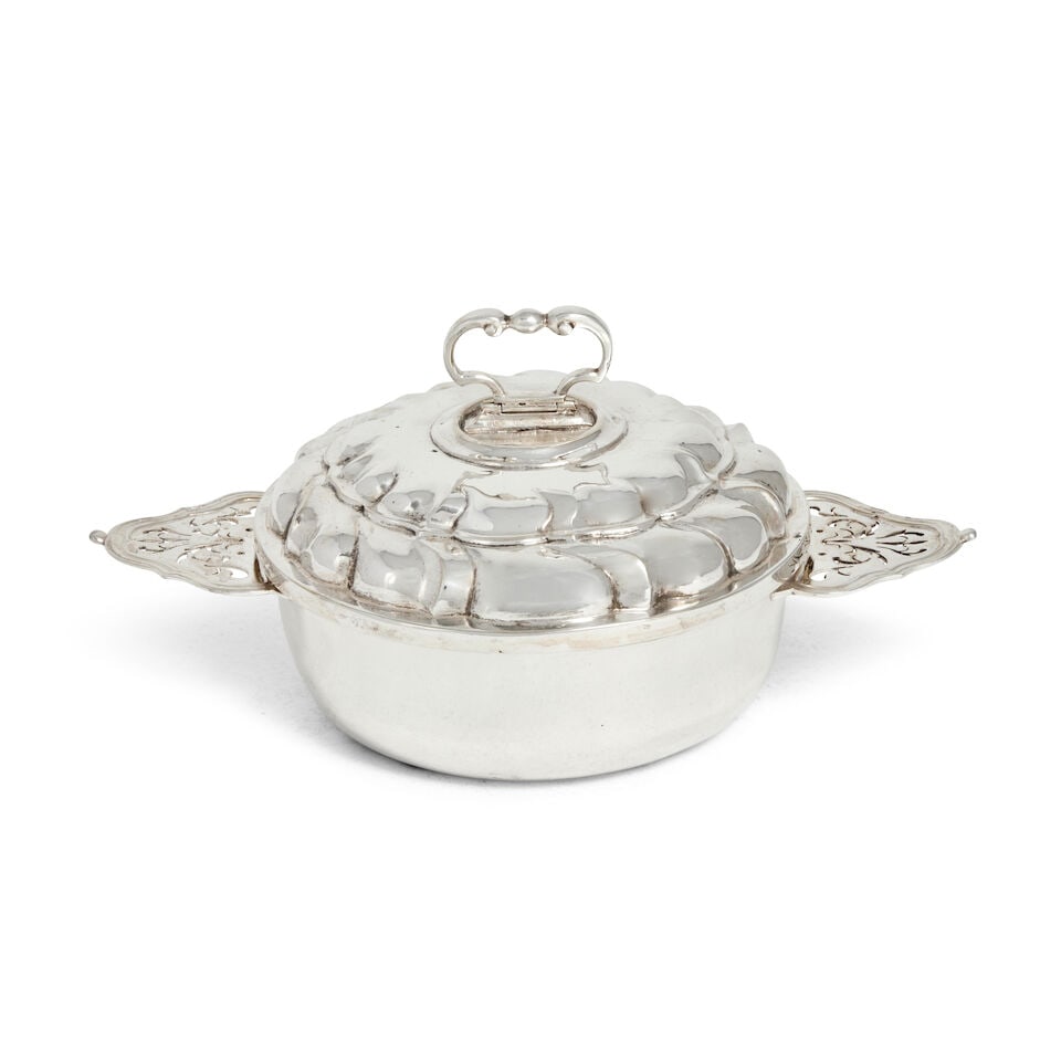 A German silver covered porringer, ecuelle maker's mark indistinct Augsburg 1745 - 1747: A German silver covered porringer, ecuelle maker's mark indistinct Augsburg 1745 - 1747 Circular form with pierced shaped-lug handles, pull-off cover, dome form with fluted sides, surmounted with a hi