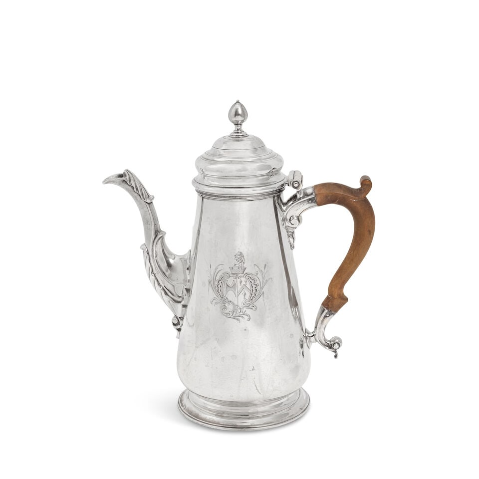 A George II silver coffee pot maker mark rubbed London 1748: A George II silver coffee pot maker mark rubbed London 1748 Plain tapering form, with stepped domed cover with acorn finial, wooden looped handle, fluted leaf-capped spout, on a spreading circular foo