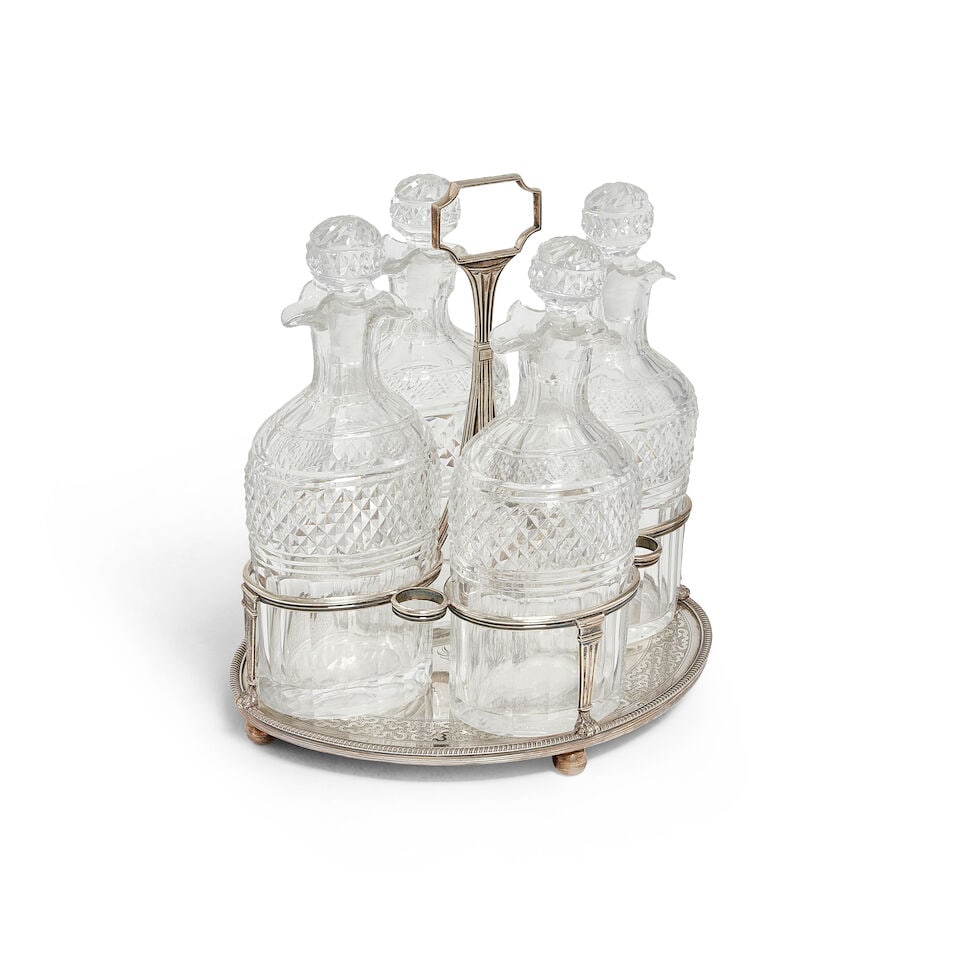 A George III silver and glass bottle decanter set Robert Hennell I & David Hennell II, London 1801: A George III silver and glass bottle decanter set Robert Hennell I & David Hennell II, London 1801 The frame, oval base with gadroon rim, with a wriggle-work engraved inner band, centred with the engr