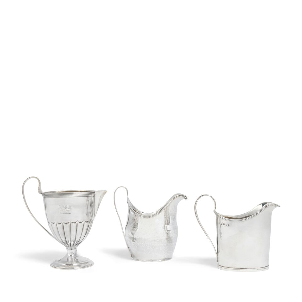 A collection of three George III silver cream jugs (3): A collection of three George III silver cream jugs Comprising: A cream jug, Robert Hennell, London, 1792, part fluted tapering form, crested, on a circular foot, height 12.5cm; A cream jug, Peter, Ann