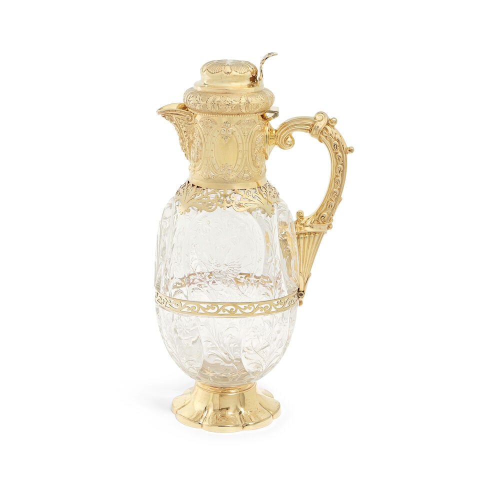 An Edwardian silver-gilt mounted glass decanter Goldsmiths & Silversmiths Co Ltd, London 1903: An Edwardian silver-gilt mounted glass decanter Goldsmiths & Silversmiths Co Ltd, London 1903 Hinged dome cover and cylindrical collar, foliate embossed and chased, pierced scroll shoulders and girdle