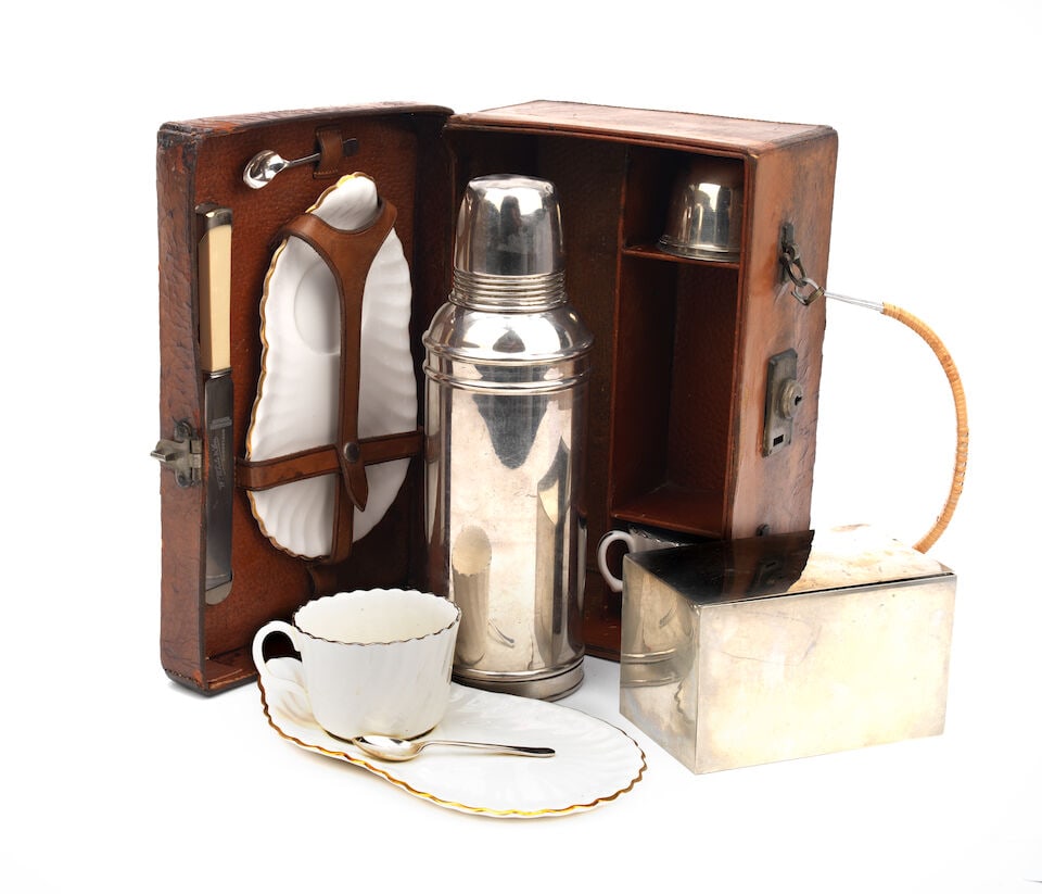 A leather-cased tea-set for two persons, by Barrett & Sons, circa 1911,: A leather-cased tea-set for two persons, by Barrett & Sons, circa 1911, honey leather case with later replacement handle, the lid with branded initials 'H.C.', opening to interior fitted with Thermos