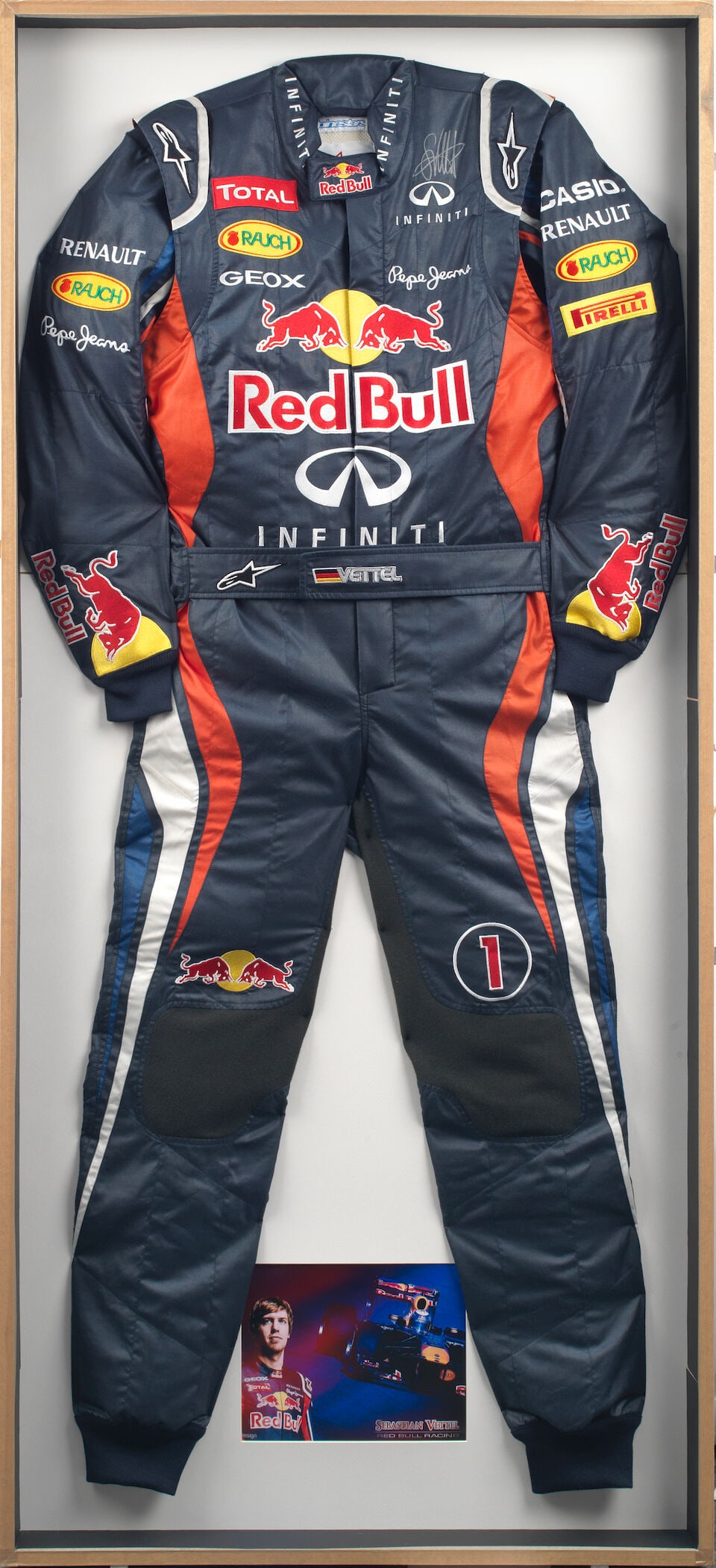A pair of signed Sebastian Vettel Red Bull Racing F1 promotional overalls, by Alpinestars,: A pair of signed Sebastian Vettel Red Bull Racing F1 promotional overalls, by Alpinestars, in blue, red and white, with sponsor logos, signed top right in silver marker, patch to inside neck line