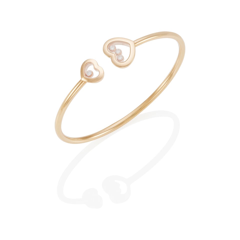 CHOPARD:18K GOLD AND DIAMOND CUFF 'HAPPY DIAMONDS' BRACELET: CHOPARD:18K GOLD AND DIAMOND CUFF 'HAPPY DIAMONDS' BRACELET • 18k yellow gold • 4 round diamonds weighing approximately 0.15 - 0.20 carat total • Signed Chopard • Inner