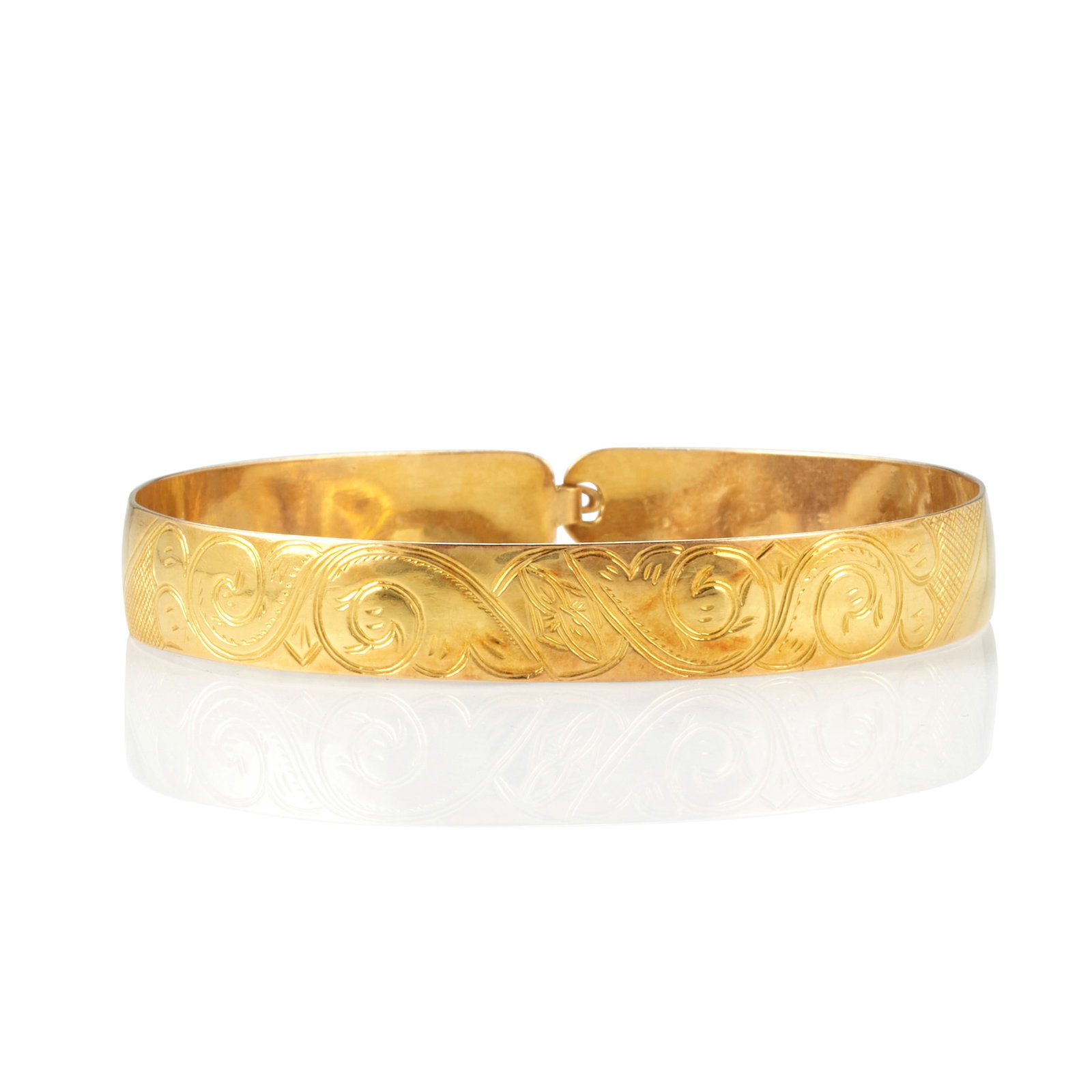 A Northwest Coast gold bracelet: A Northwest Coast gold bracelet A slightly concave 22K gold bangle chased and engraved with abstract foliate designs over a geometric ground, apparently unmarked. inner circumference 6 1/2in, width 3/