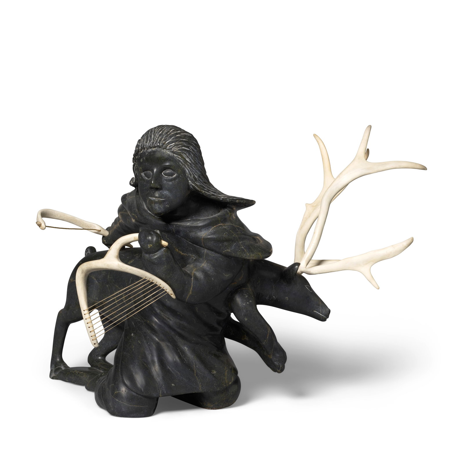 A Lukta Qiatsuk stone sculpture: Lukta Qiatsuk Inuit, Kinngait (Cape Dorset), (1928-2004), untitled, stone and caribou antler, depicting a caribou beside a herder carrying a stringed instrument, possibly a tautirut or a bow harp, sig