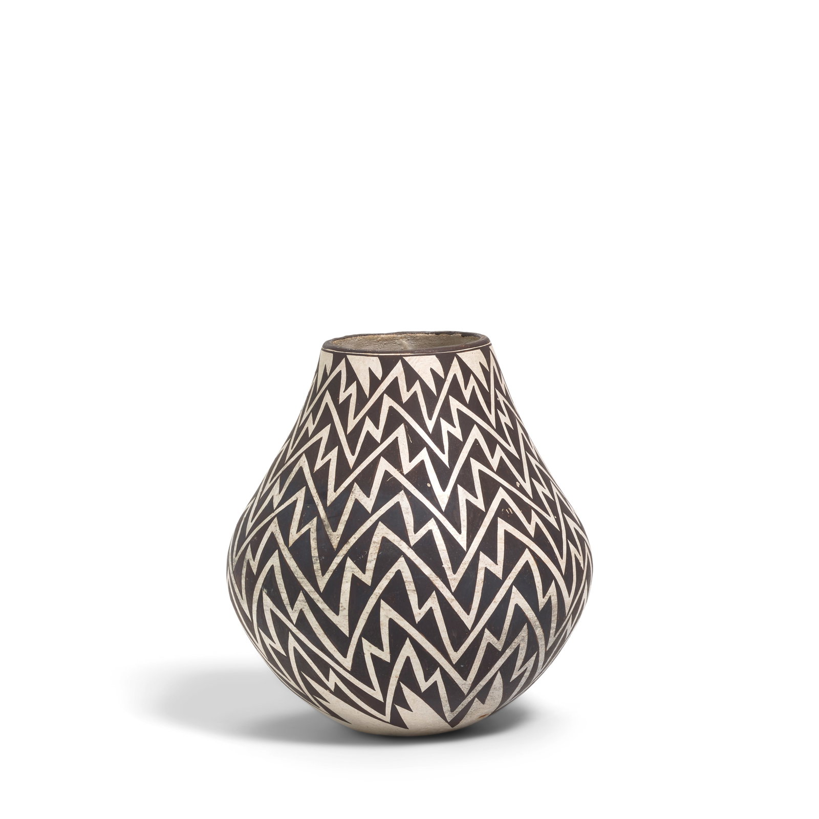 A Lucy Lewis pottery jar, 1973: Lucy M. Lewis Acoma Pueblo, (1890-1992), a black-on-white pottery jar with repeating serrated design, 1973, signed, dated and inscribed on the underside, restored. height 8 3/8in, diameter 7 1/2in