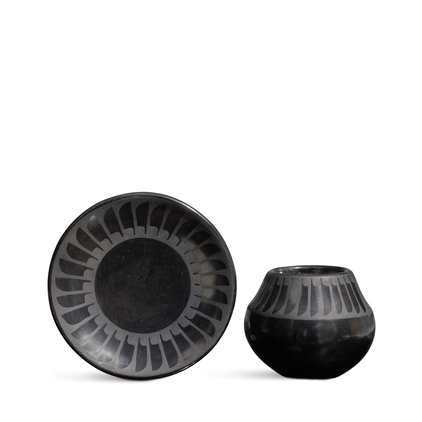 Two Maria and Santana Martinez blackware pottery objects: Maria and Santana Martinez San Ildefonso Pueblo, (1887-1980 and 1909-2002), two blackware pottery objects, including a petite plate and jar, each with repeating abstract feather border, each signed on