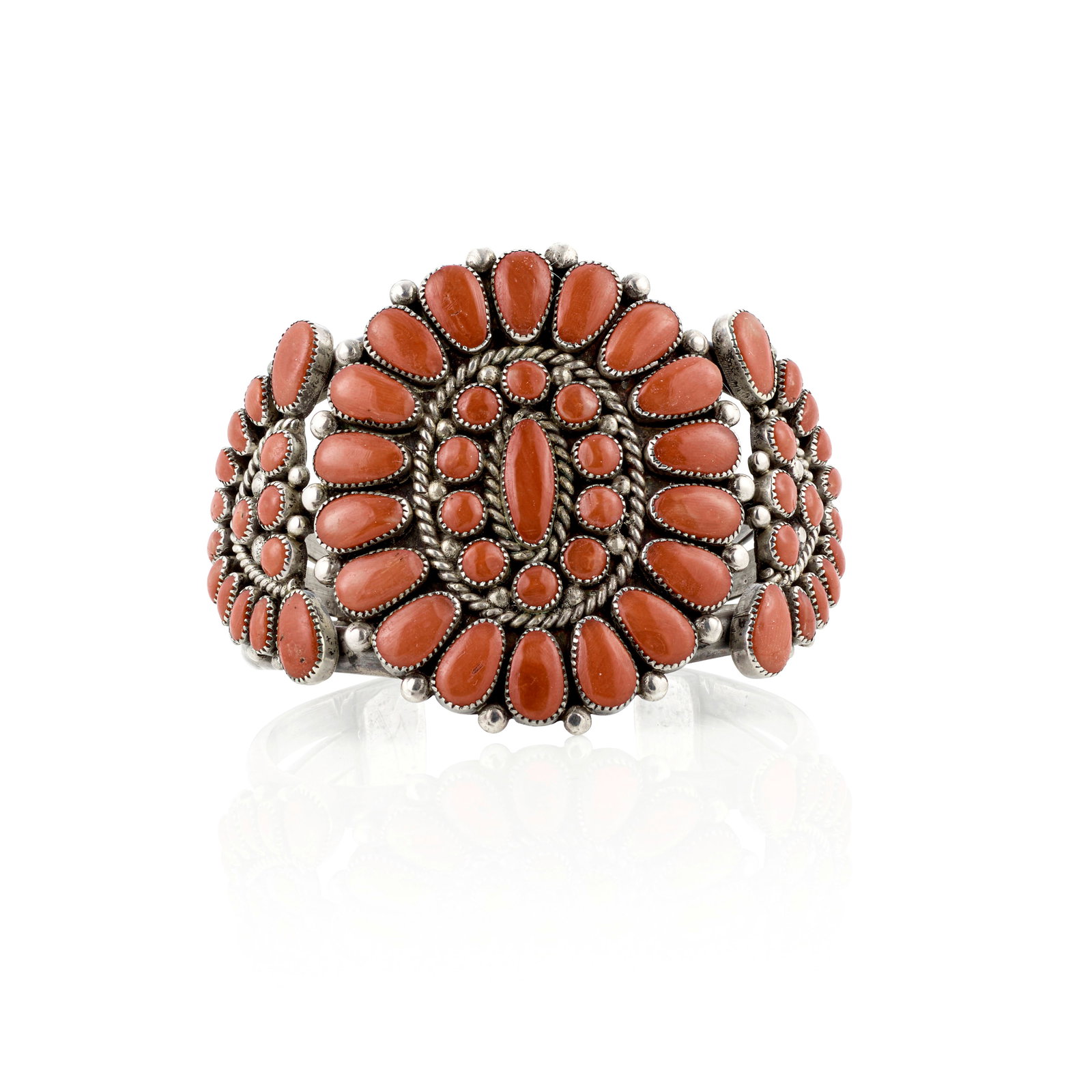 An Alice Quam cuff bracelet: Alice Quam Zuni, (1929-2003), a silver cuff bracelet, constructed from three domed wires supporting clusters of teardrop-shaped, circular and oblong red coral, with twisted wire and drop accents, stam