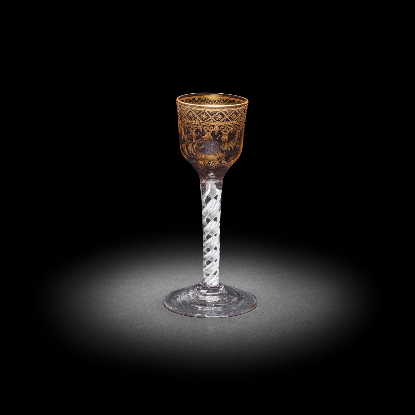 A fine Giles gilded opaque twist wine glass, circa 1765: A fine Giles gilded opaque twist wine glass, circa 1765 The ogee bowl finely gilded with a so-called 'Grubbe' border of trellis and scrolls, scattered sprigs of flowers to the lower part, with a gilt-