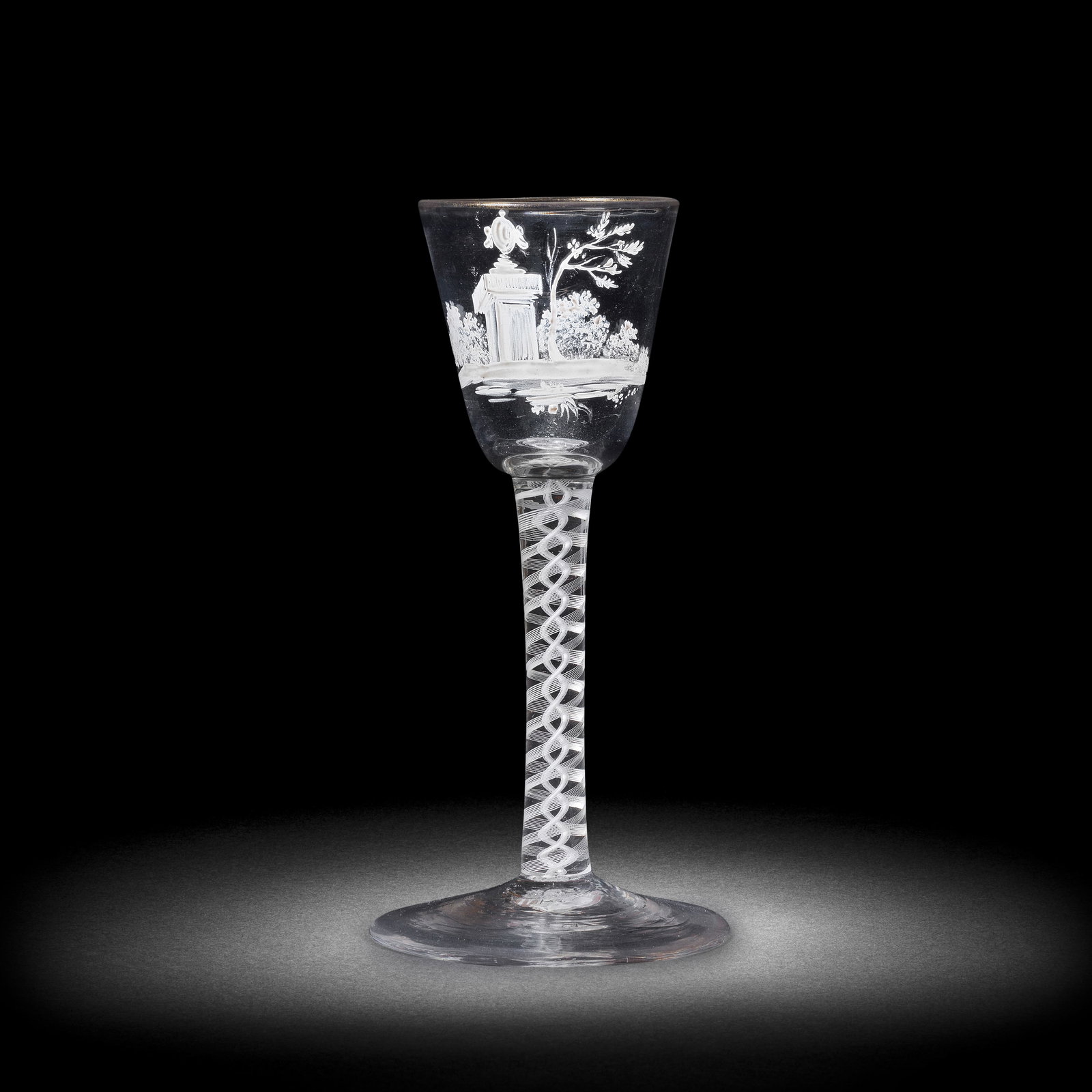 A rare Beilby enamelled opaque twist wine glass with an urn, circa 1765: A rare Beilby enamelled opaque twist wine glass with an urn, circa 1765 The round funnel bowl painted in opaque white with a landscape vignette featuring an urn set on a square plinth, flanked by a tr