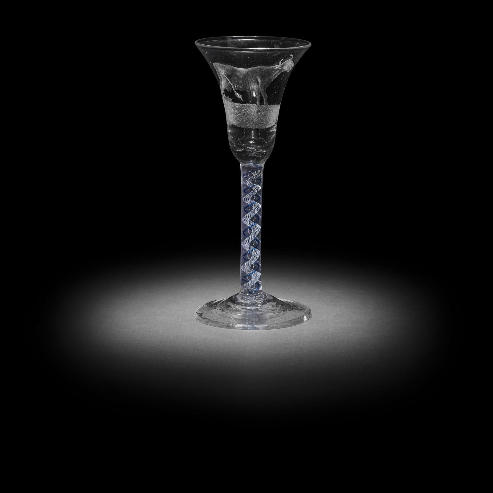 A rare engraved mixed blue colour twist wine glass, circa 1765: A rare engraved mixed blue colour twist wine glass, circa 1765 The bell bowl finely engraved with a standing cow, the stem with a spiral air gauze encircled by a single translucent blue spiral thread,