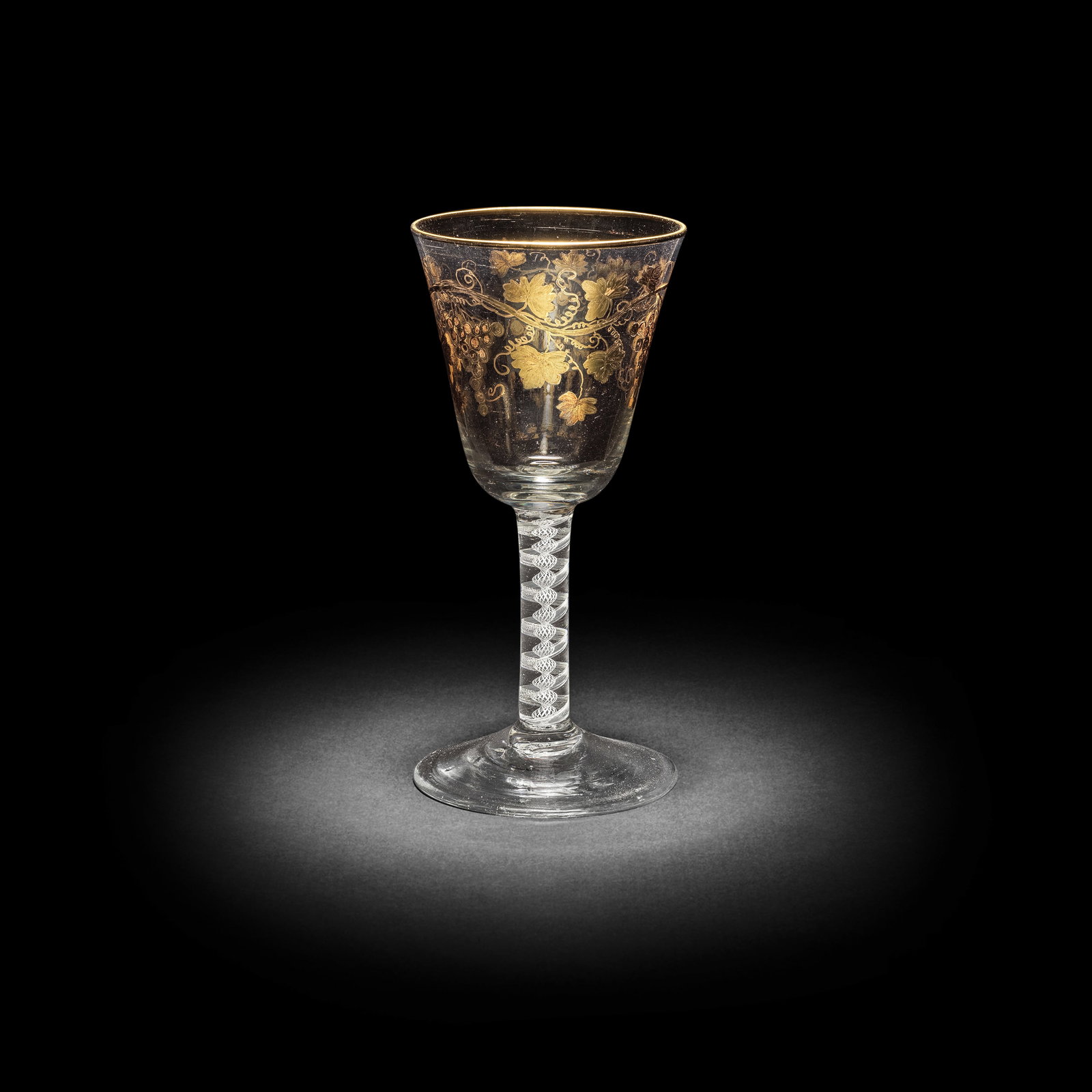 A Giles gilded opaque twist goblet, circa 1765-70: A Giles gilded opaque twist goblet, circa 1765-70 Decorated in the London workshop of James Giles, the generous round funnel bowl decorated with a meandering branch of fruiting vine, the rim gilt, on