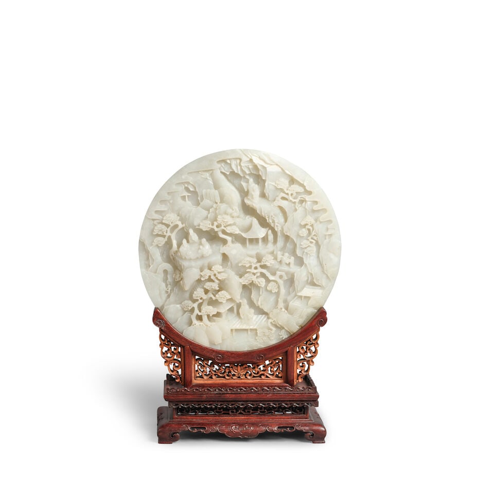 AN INSCRIBED WHITE JADE 'LANDSCAPE' TABLESCREEN 20th century (wood stand): AN INSCRIBED WHITE JADE 'LANDSCAPE' TABLESCREEN 20th century The reverse side inscribed with a Tang dynasty poem 'Wu Wang Changling Yinju' in gilt. 10 7/8in (27.5cm) diam of plaque; 15 1/2in (39.5cm)